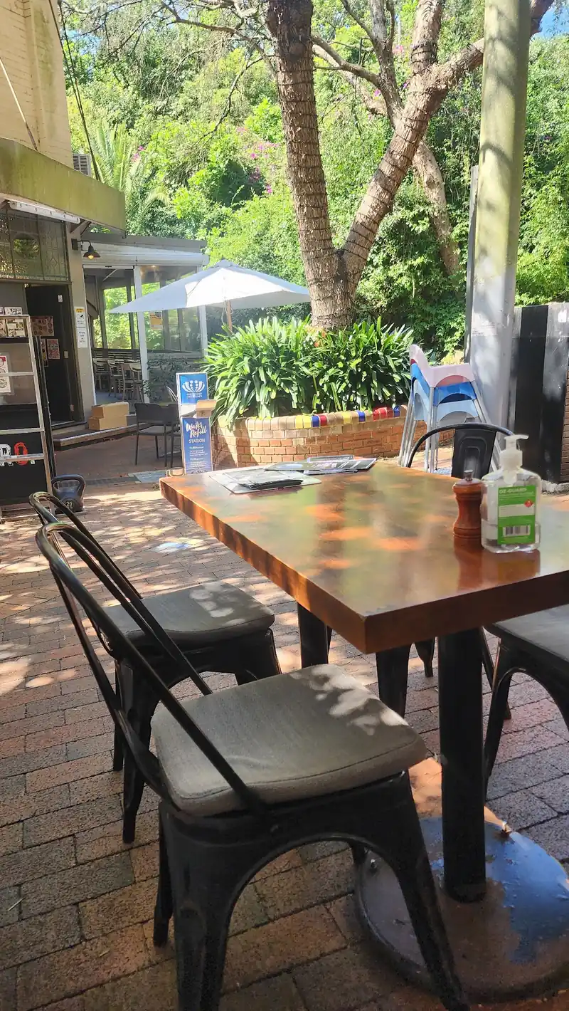 Outdoor tables in the leafy laneway outside The Wilkes